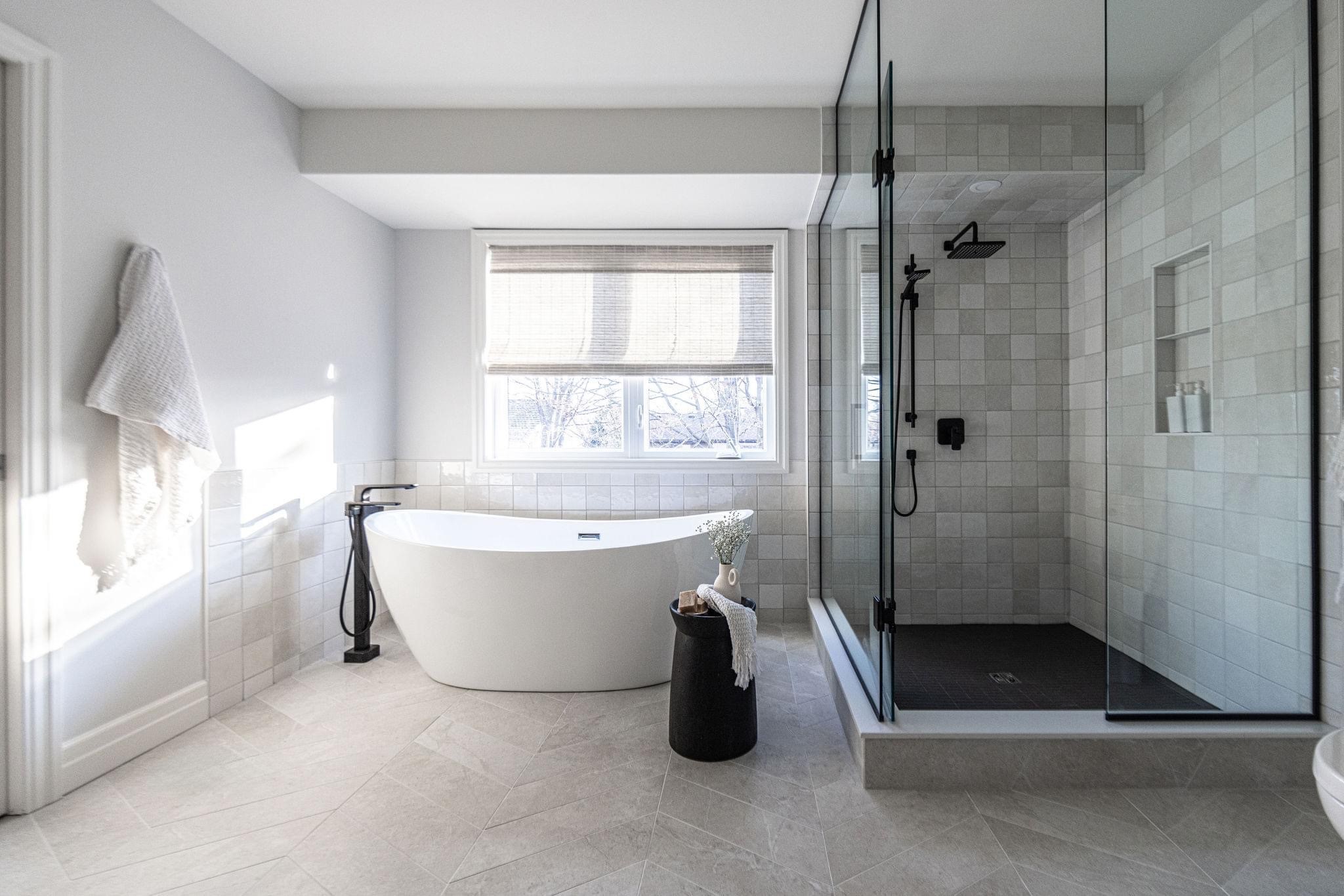 Master bathroom wide angle — glass shower enclosure and herringbone floor tile