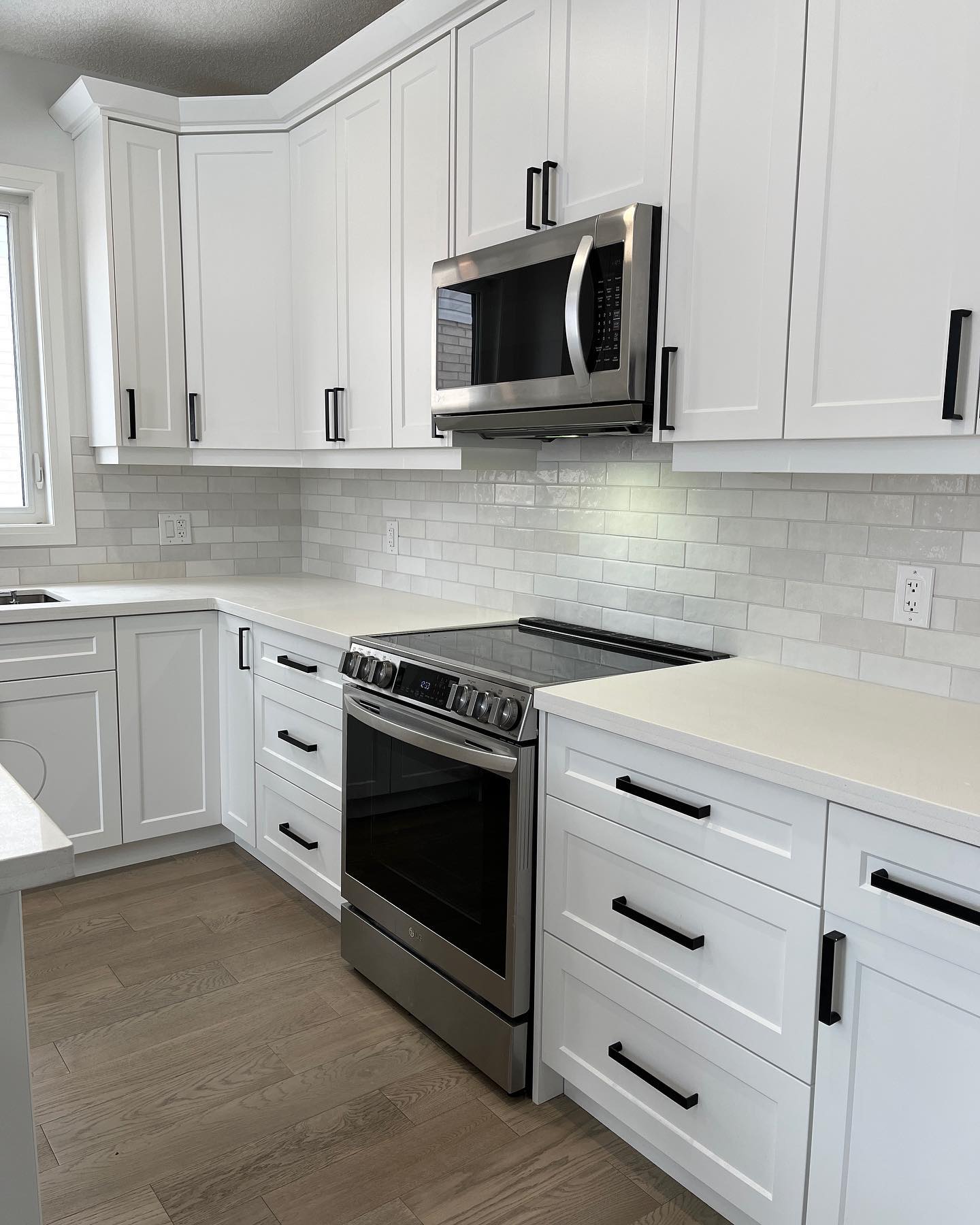 Modern kitchen subway tile backsplash with white quartz counters